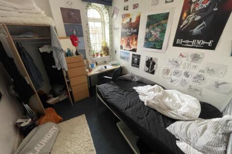 This cozy double bedroom features ample natural...