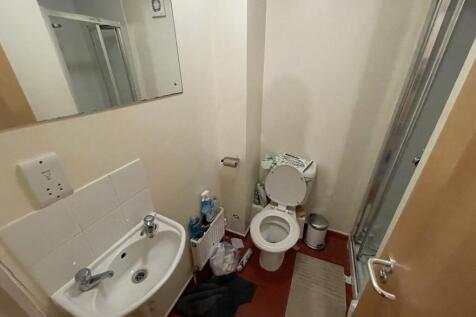 A compact bathroom featuring a white sink with ...