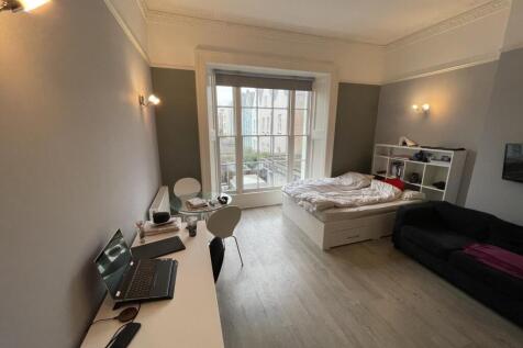 A stylish master bedroom featuring a large wind...