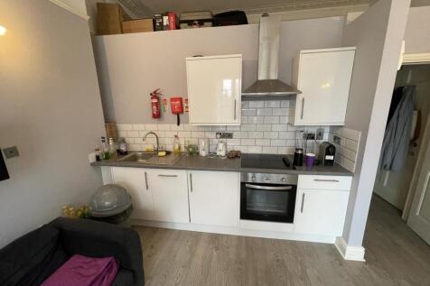 Modern kitchen area with white cabinetry, a sta...