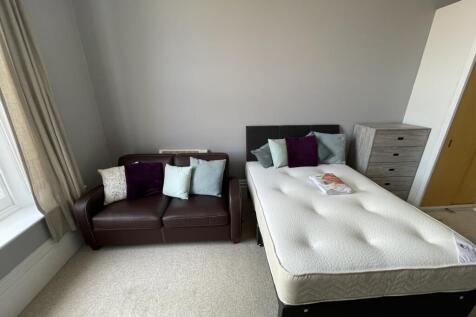 A bright double bedroom featuring a comfortable...