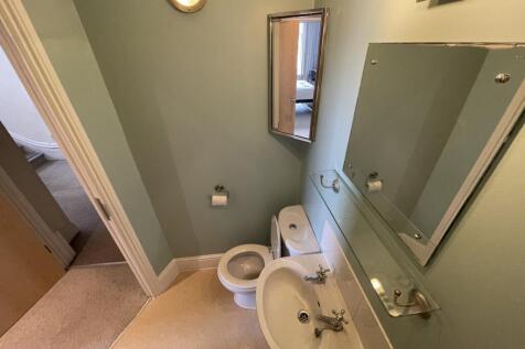 A clean and simple single toilet room featuring...