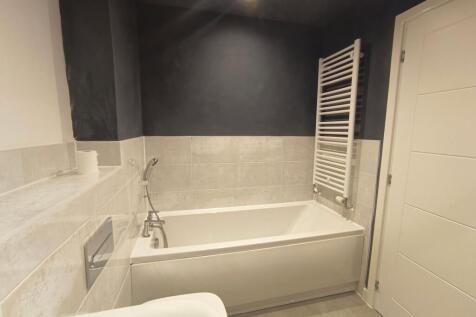 A modern bathroom featuring a clean white batht...