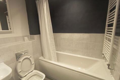 A modern bathroom suite featuring a clean white...