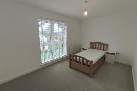 A clean and bright single bedroom featuring a w...