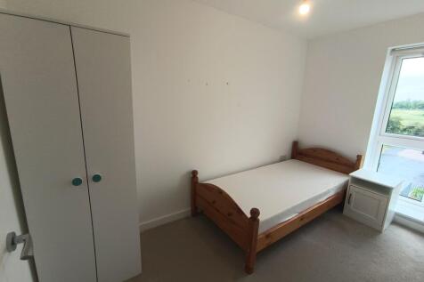 A bright and tidy single bedroom featuring a wo...
