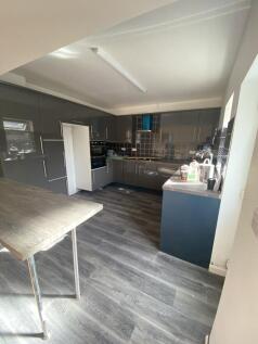 Modern kitchen featuring sleek grey cabinetry w...