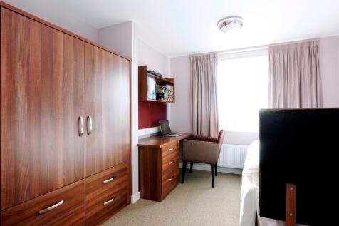 A bright and tidy single bedroom featuring a la...