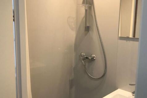 A clean, modern bathroom with a wall-mounted sh...