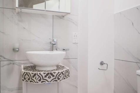 A modern bathroom featuring elegant marble-effe...