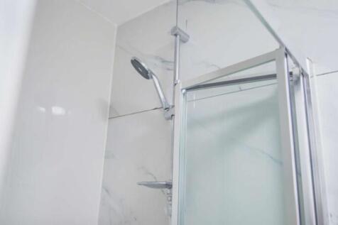 Modern bathroom shower area with a sleek overhe...