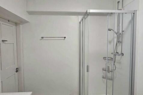 A clean and modern bathroom featuring a glass-e...
