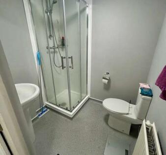A modern bathroom featuring a glass-enclosed sh...