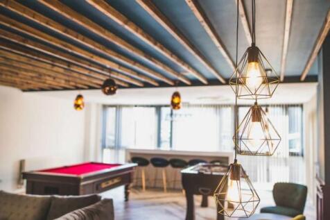 A stylish communal lounge featuring modern pend...
