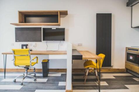 A modern communal workspace featuring a clean, ...