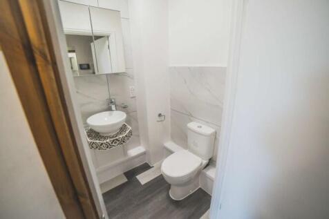 A modern and tidy single toilet room featuring ...