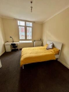 A bright double bedroom featuring a large windo...