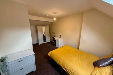 A cozy double bedroom featuring a bright yellow...