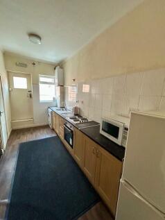 A long, well-maintained kitchen featuring woode...