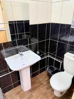 Compact and clean bathroom featuring modern bla...