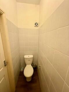 A compact and clean single toilet with white ti...
