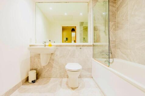 A modern bathroom suite featuring a clean white...