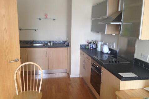 A modern kitchen featuring light wood cabinets,...
