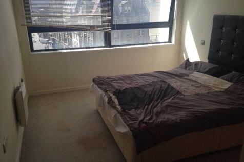 A cozy double bedroom featuring a large window ...