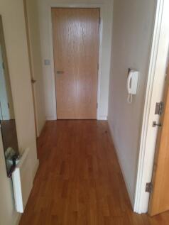 A neat and simple hallway featuring wood floori...