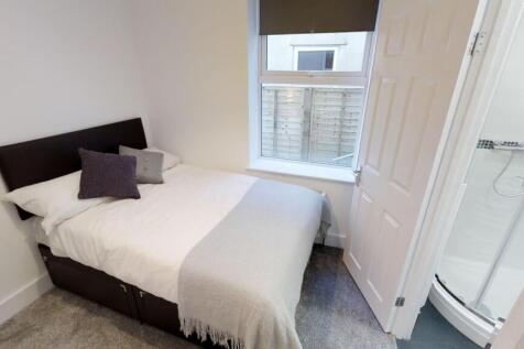 A neat and tidy double bedroom featuring a comf...
