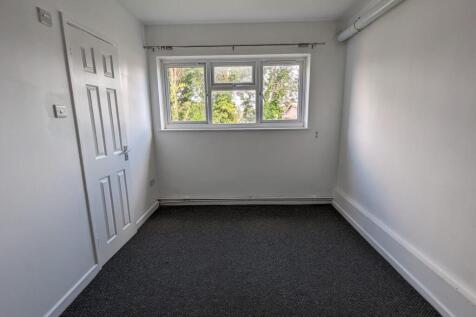 A clean and well-lit single bedroom with neutra...