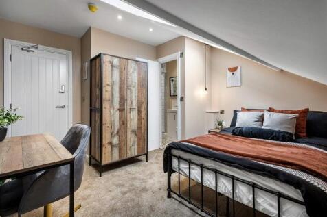 A stylish and cozy master bedroom featuring a c...