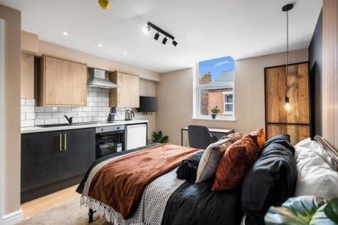A modern and stylish studio bedroom featuring a...