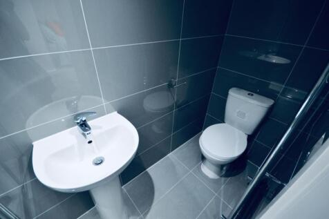 A modern and sleek single toilet area featuring...