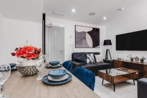 A stylish and contemporary living room featurin...