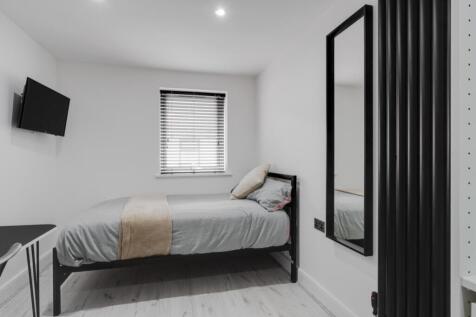 This cozy double bedroom features a comfortable...