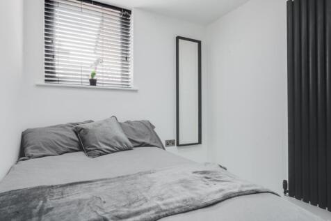 This inviting double bedroom features a comfort...
