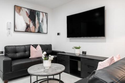 This contemporary living room features sleek bl...