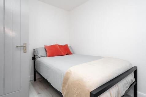 This inviting double bedroom features a cozy be...