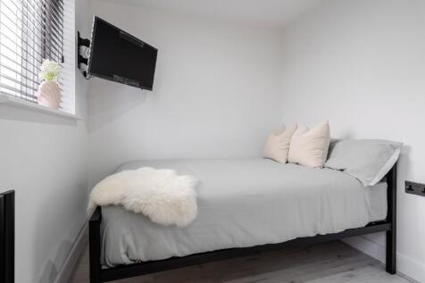 This cozy double bedroom features a comfortable...