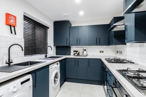 This modern kitchen features sleek blue cabinet...