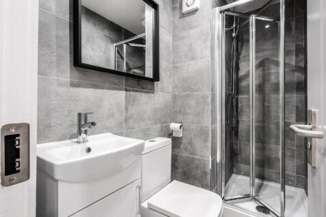 A modern bathroom featuring sleek grey tiles, a...