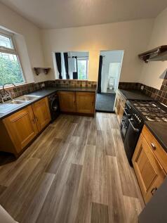 Bright kitchen featuring wood cabinetry and mod...