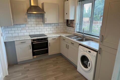 A bright, modern kitchen featuring marble-effec...