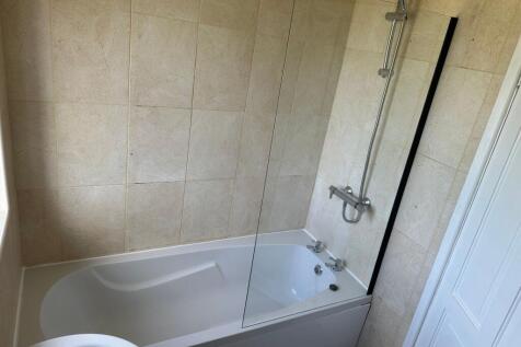A modern bathroom suite featuring a clean white...