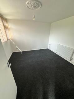 A clean and simple single bedroom with dark car...