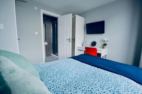 This cozy double bedroom features a comfortable...