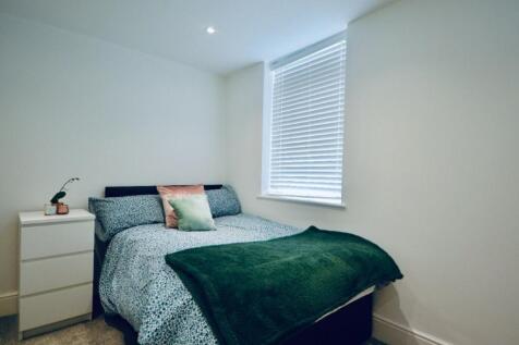 This cozy double bedroom features a comfortable...