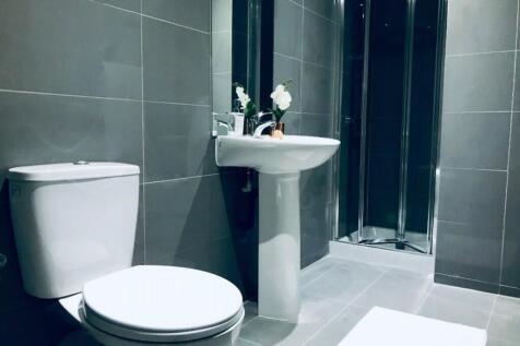 A modern bathroom featuring sleek grey tiles, a...