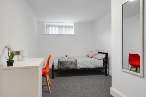 This cozy single bedroom features a modern desi...